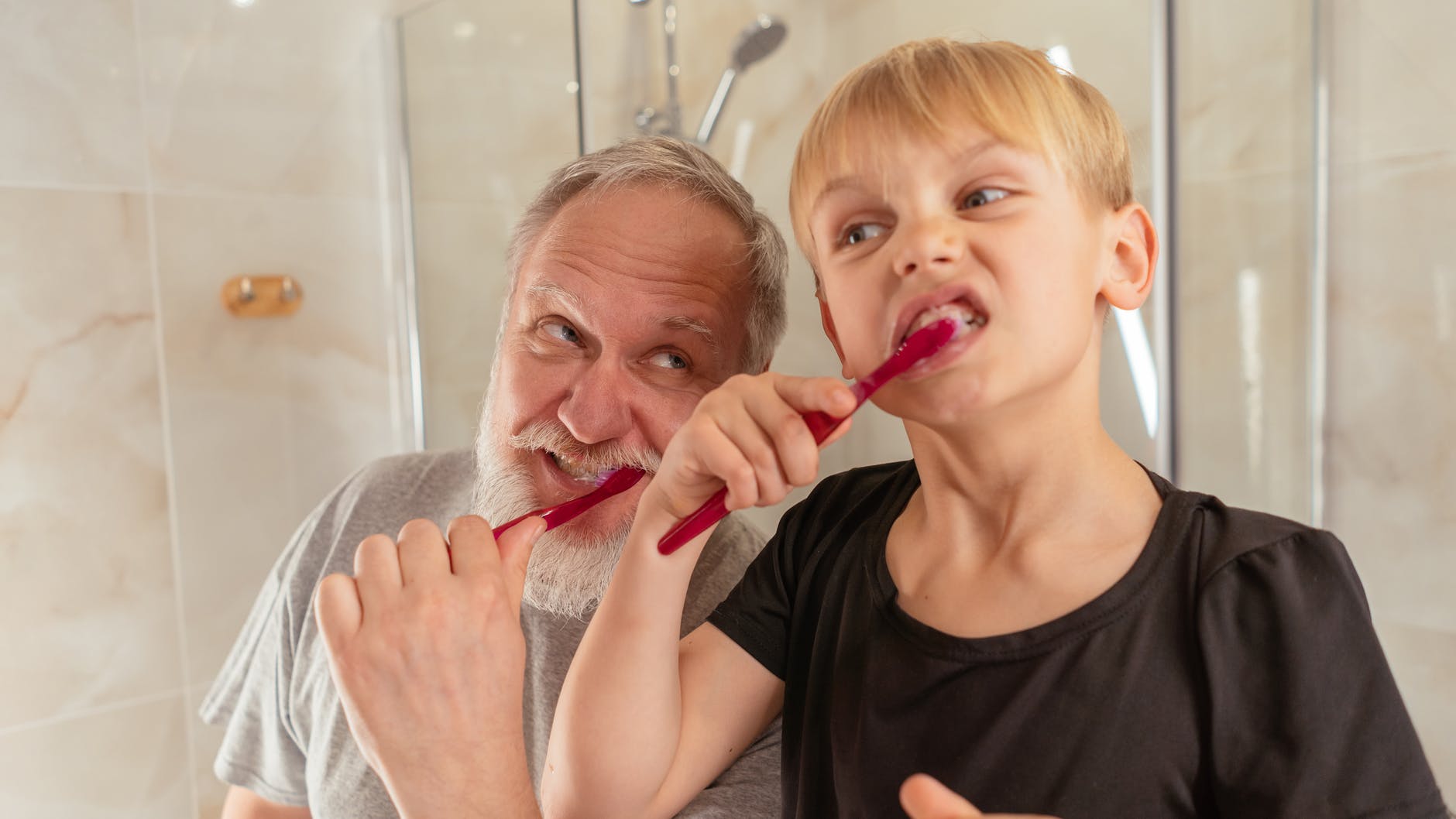 man brushing his teeth with his grandson