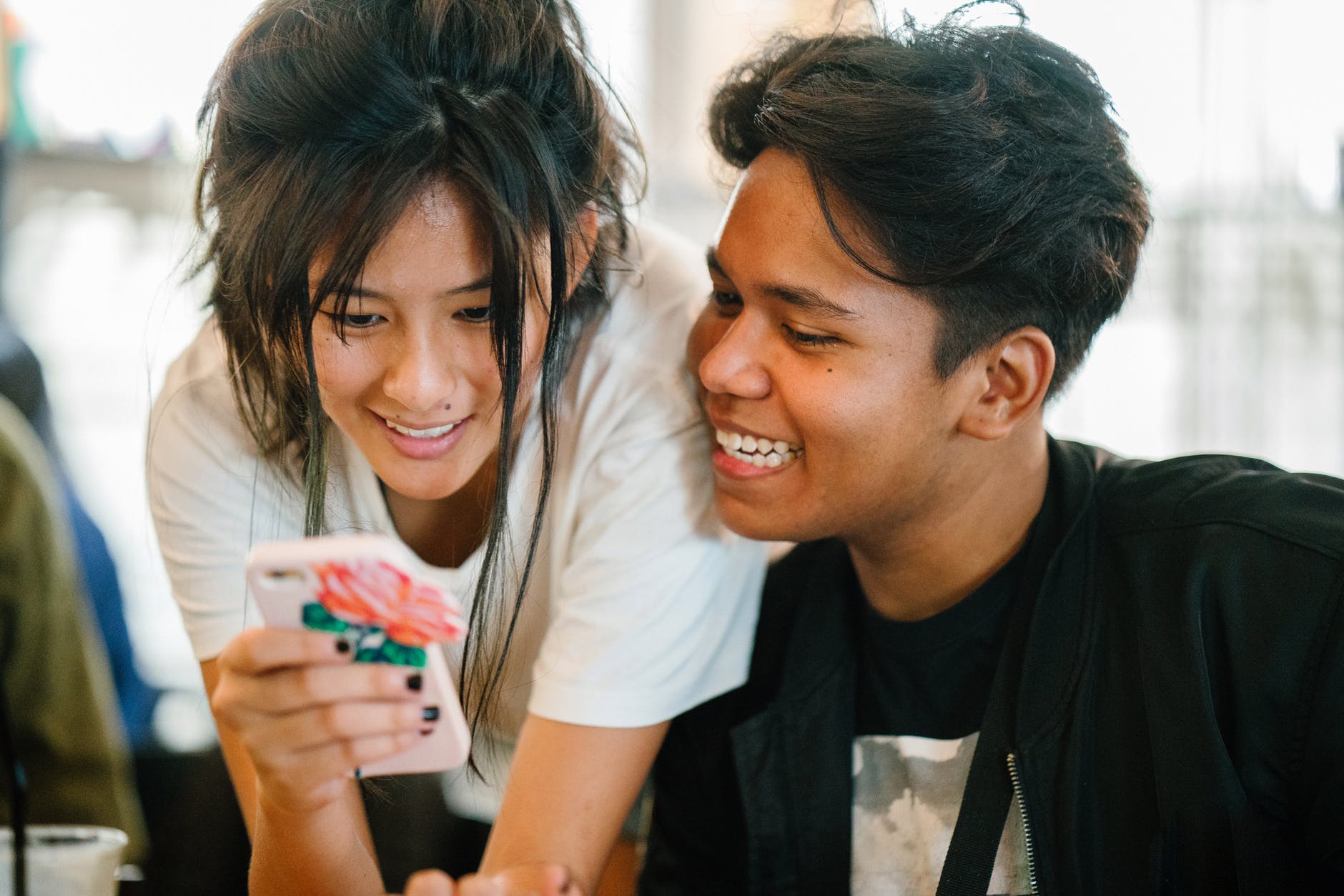 woman standing near man while carrying smartphone