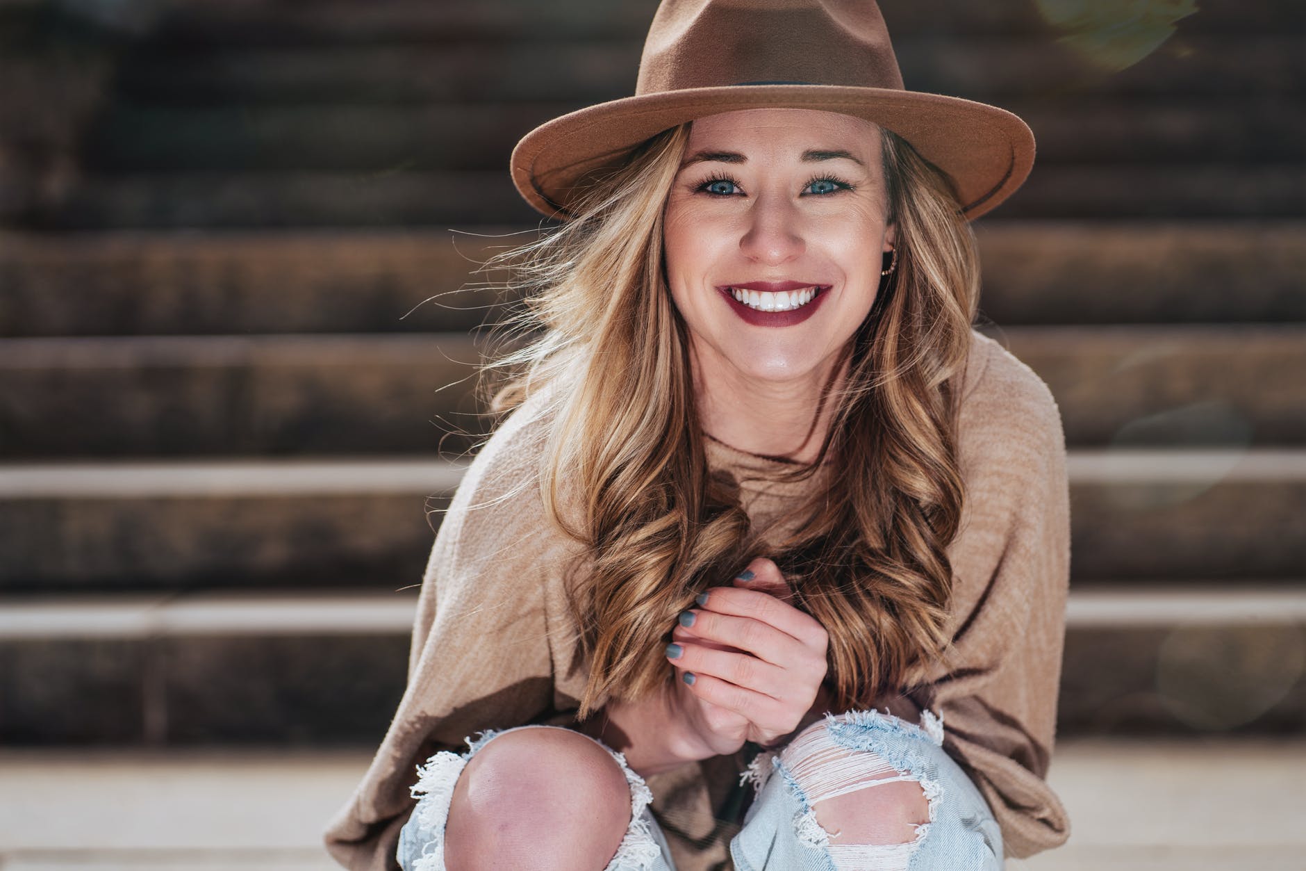joyful young woman sitting on street stairs