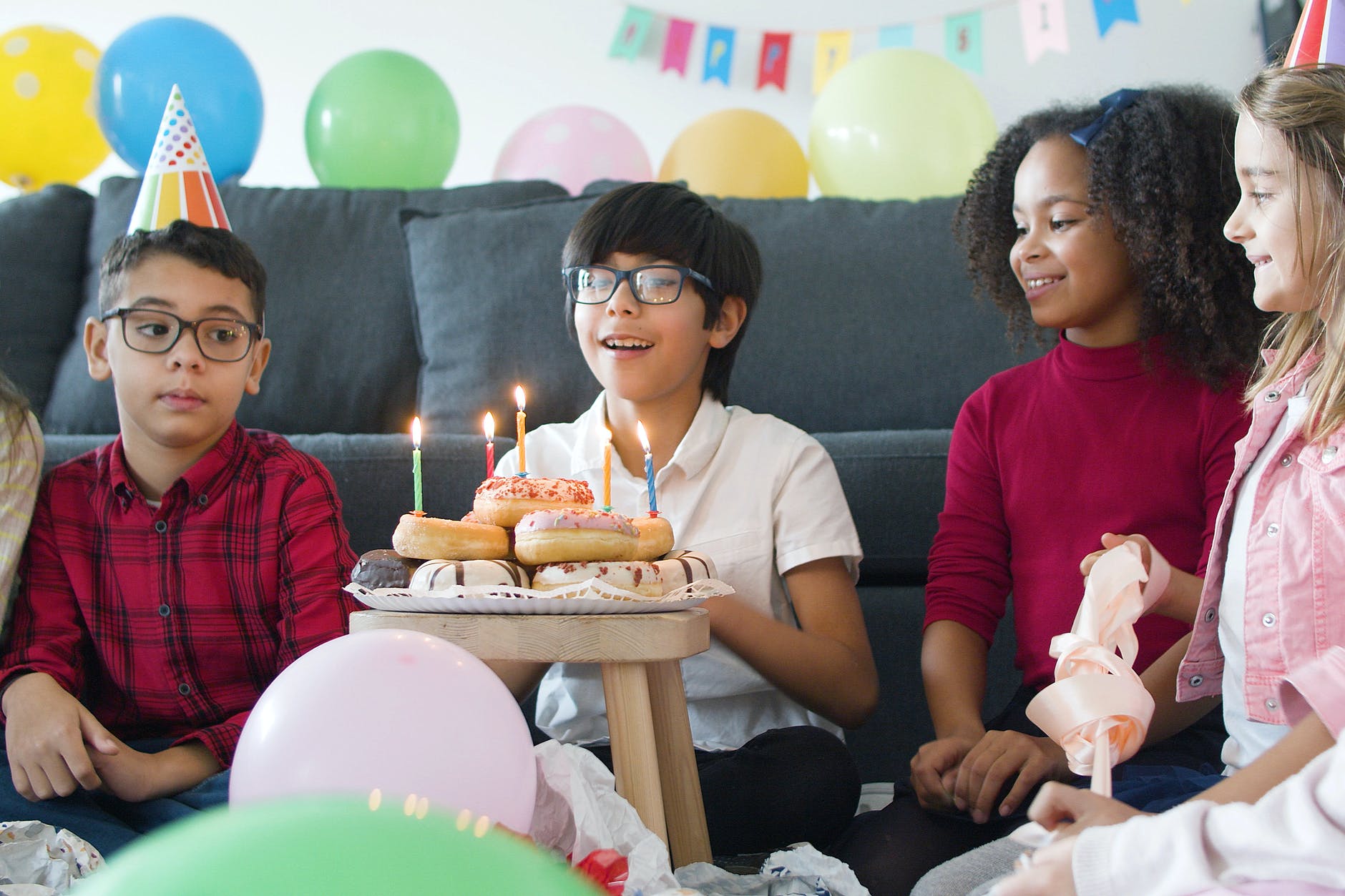 kids looking at the birthday celebrant while making a wish