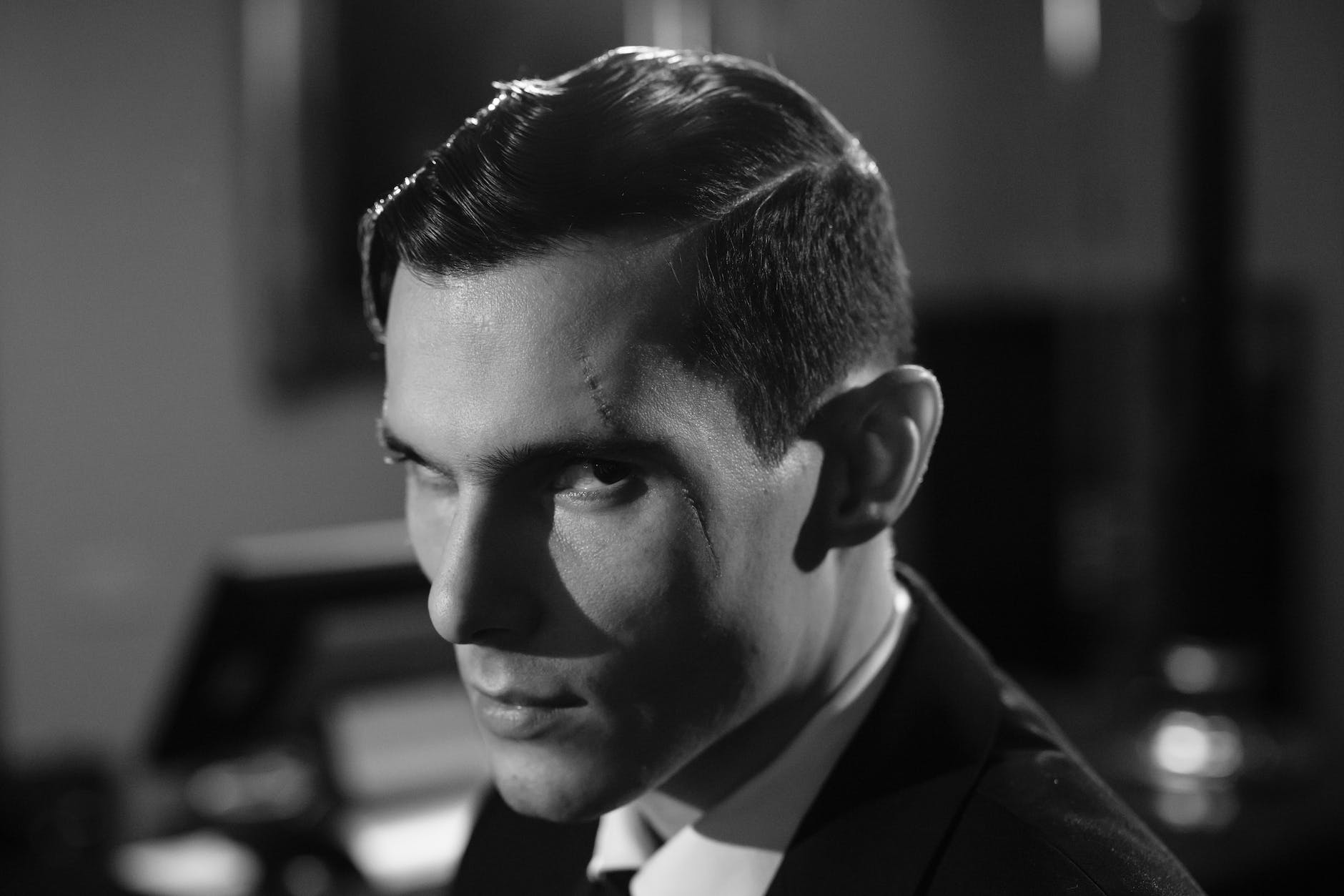close up photo of serious man with scar on his face