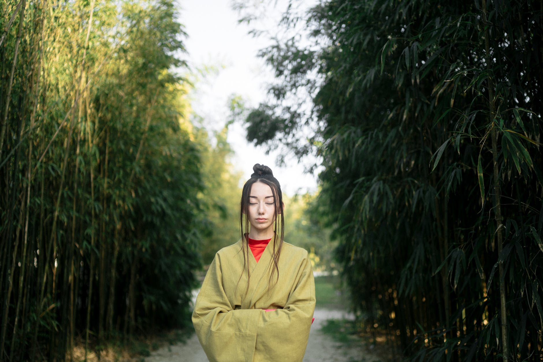 woman in green kimono standing near green trees