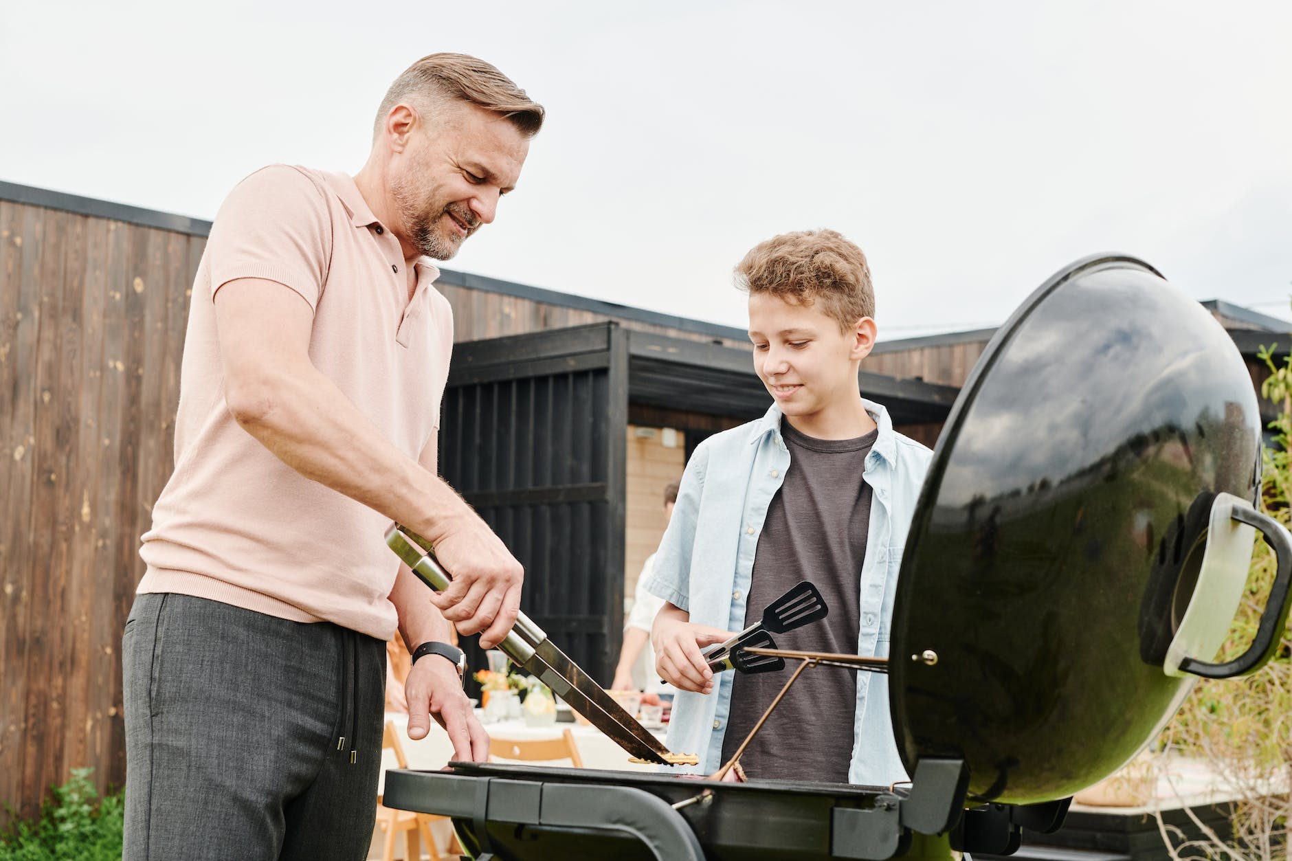 a father grilling outdoors with his son