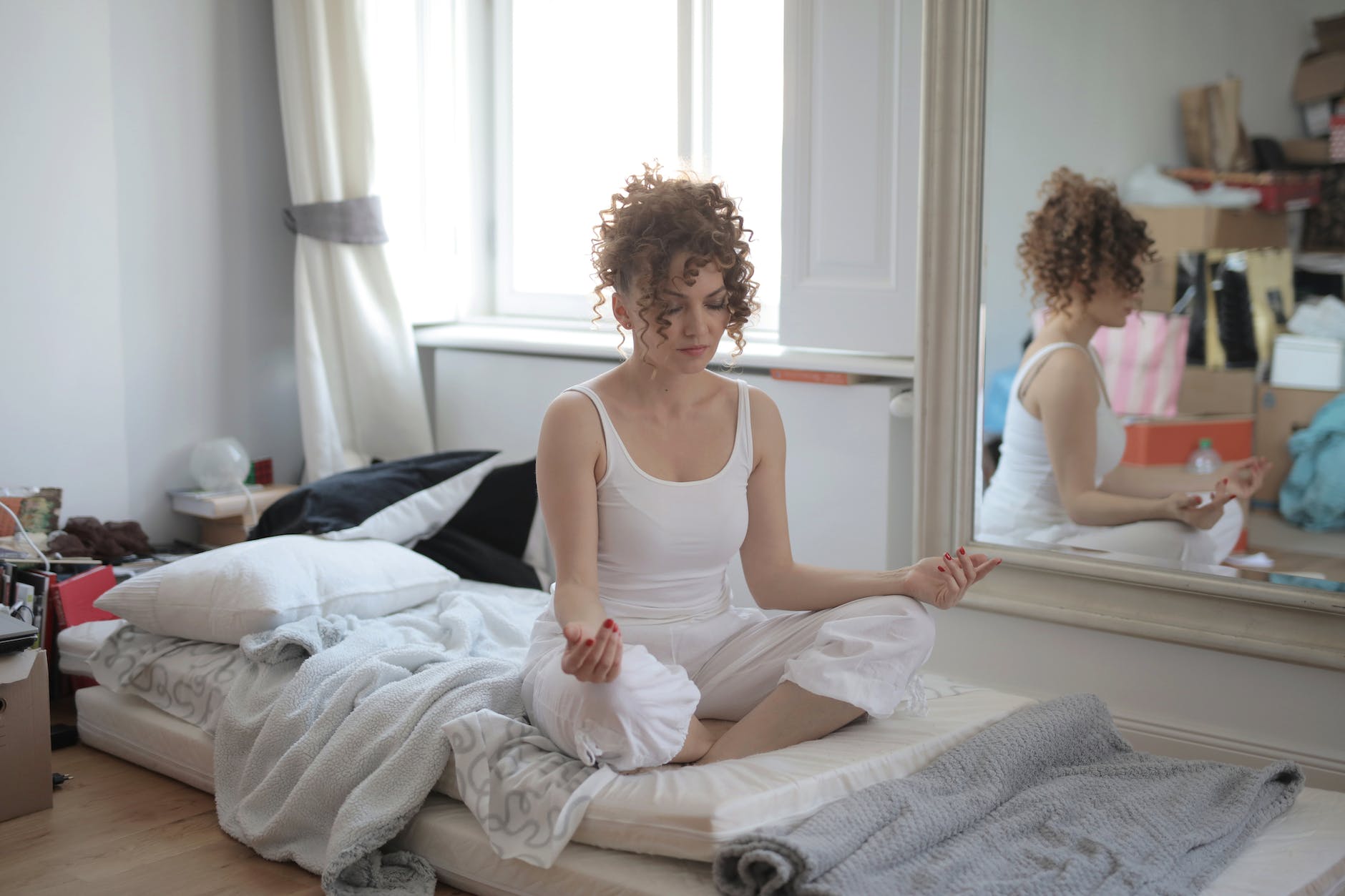 calm woman in lotus pose meditating after awakening at home