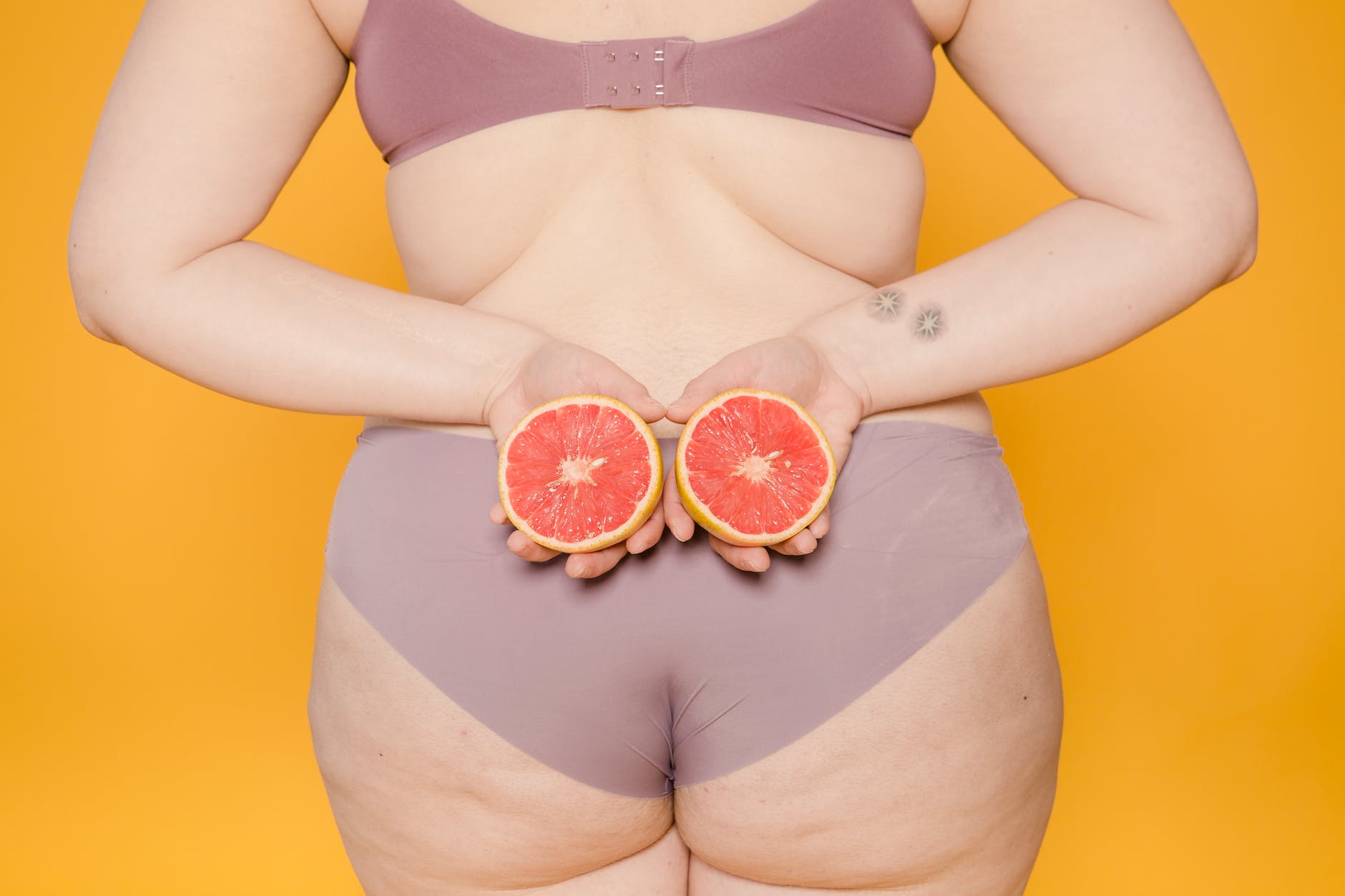 faceless model in lingerie with cut grapefruit