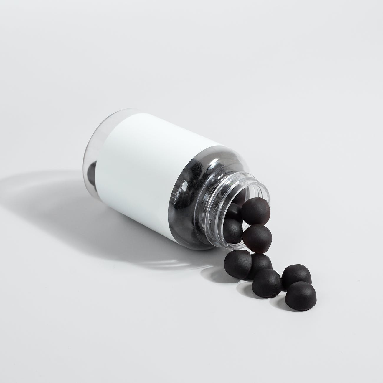 close up shot of black supplement gummies on white surface