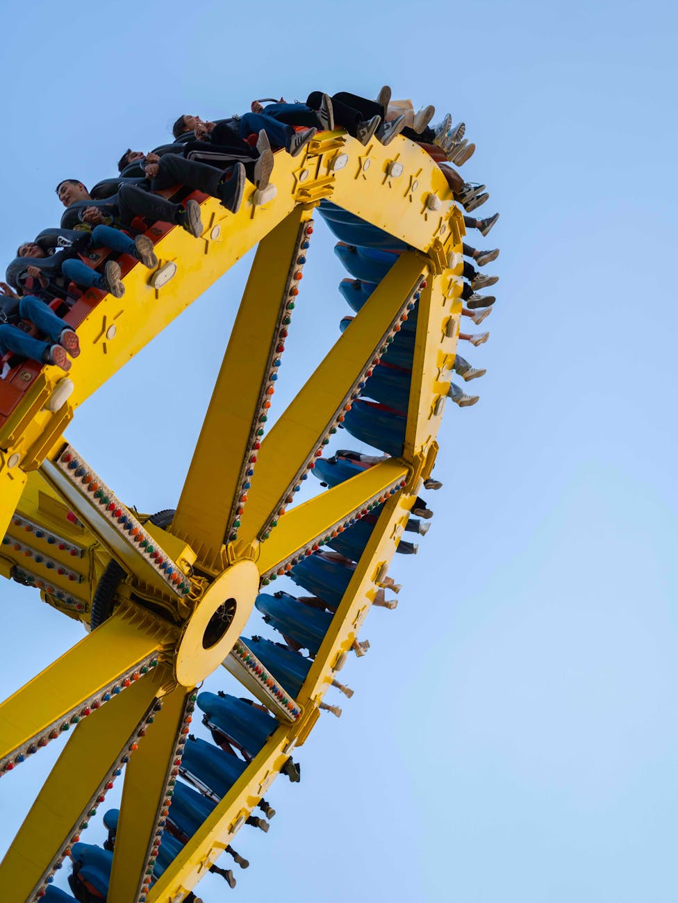 thrilling yellow ferris wheel ride against blue sky