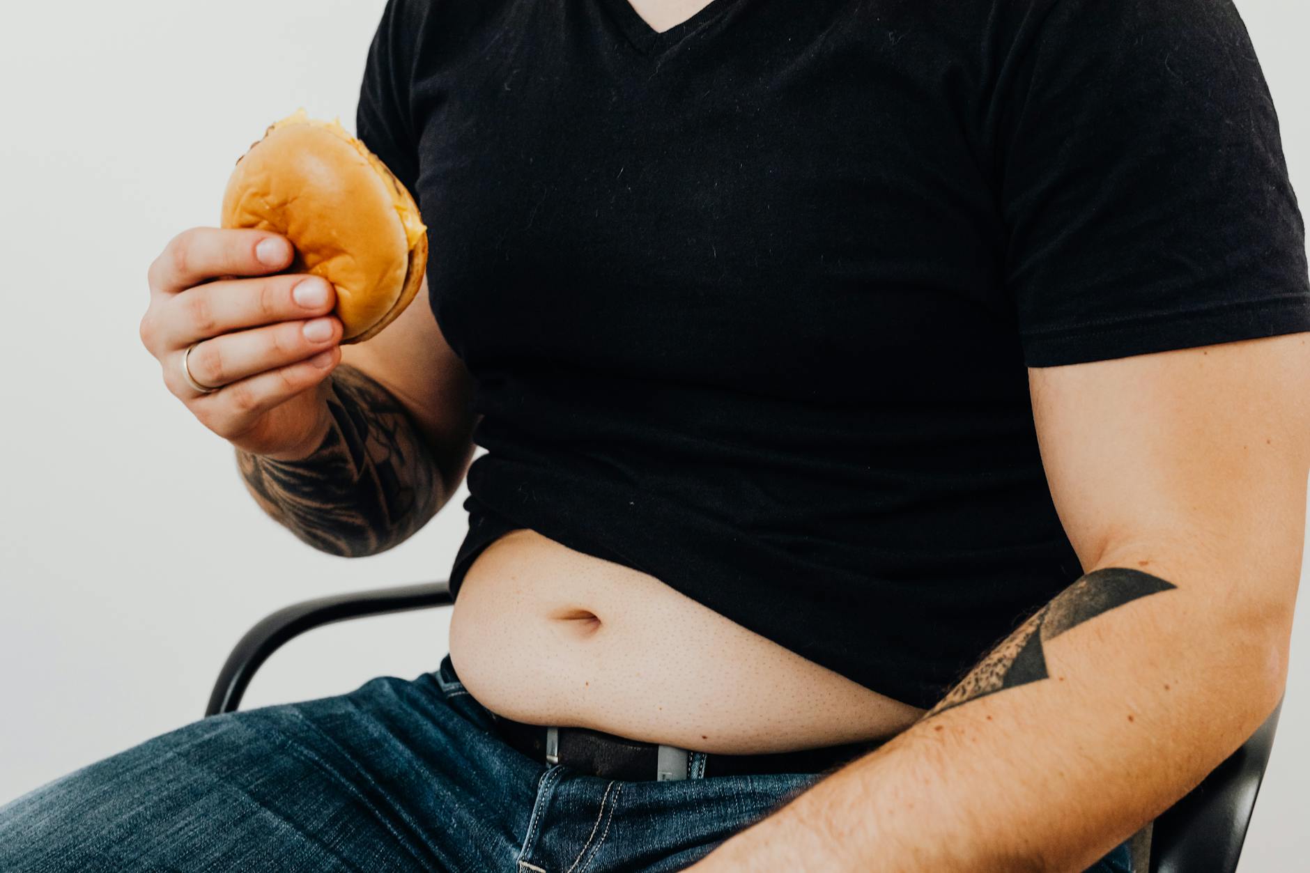 a man in black shirt holding a burger