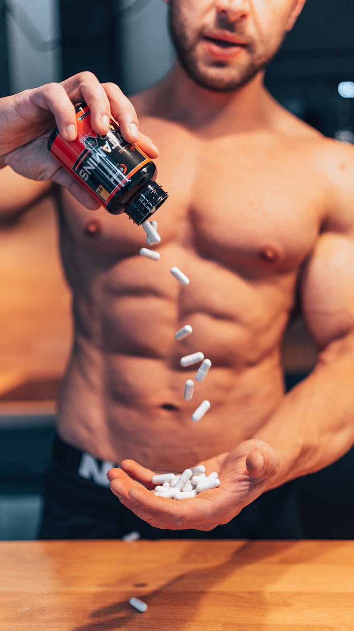 shirtless man throwing pills out of a bottle